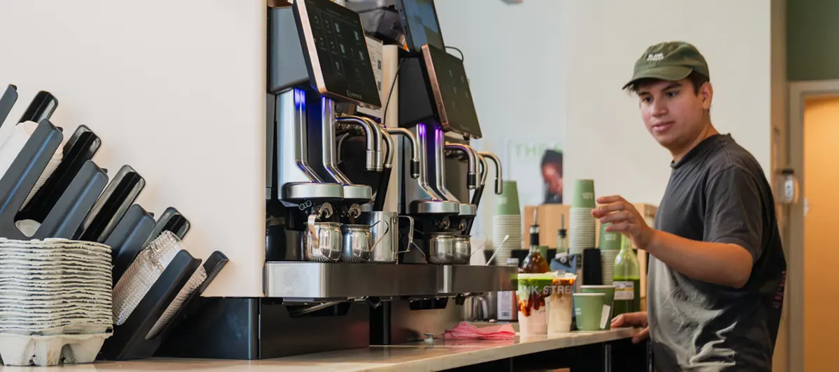 Barista arbetar vid en rad Eversys-maskiner