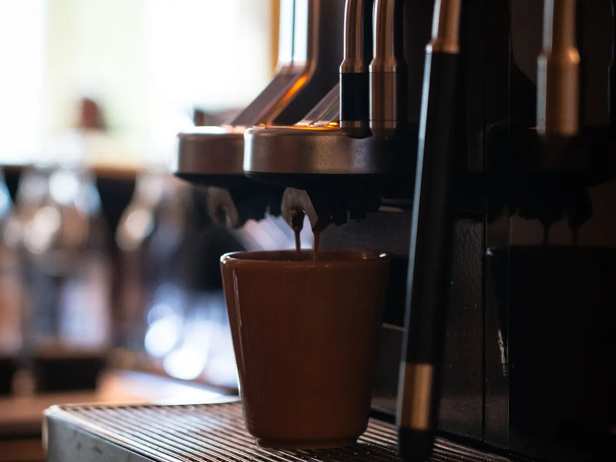Espresso rinner ner i en brun kopp under en Eversys