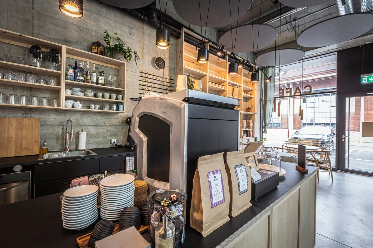 Eversys Cameo på disken i ett café med hyllor och kaffepåsar