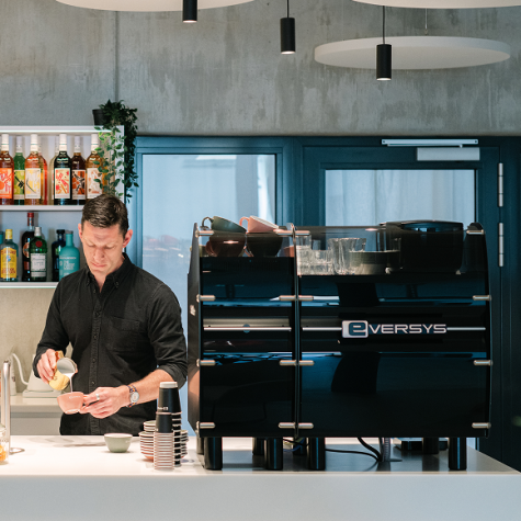 Barista som serverar kaffe med en kaffemaskin i ett hotell