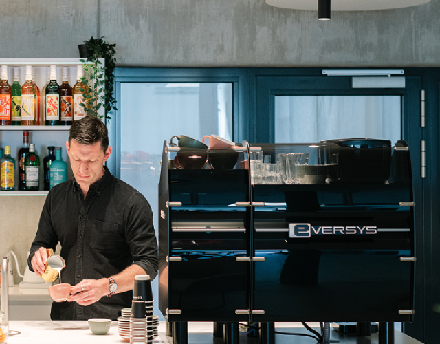 Barista som serverar kaffe med en kaffemaskin i ett hotell