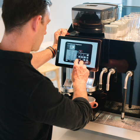 Barista som använder en shotmaster espressomaskin i ett café