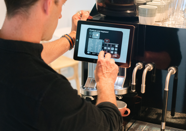Barista som använder en shotmaster espressomaskin i ett café